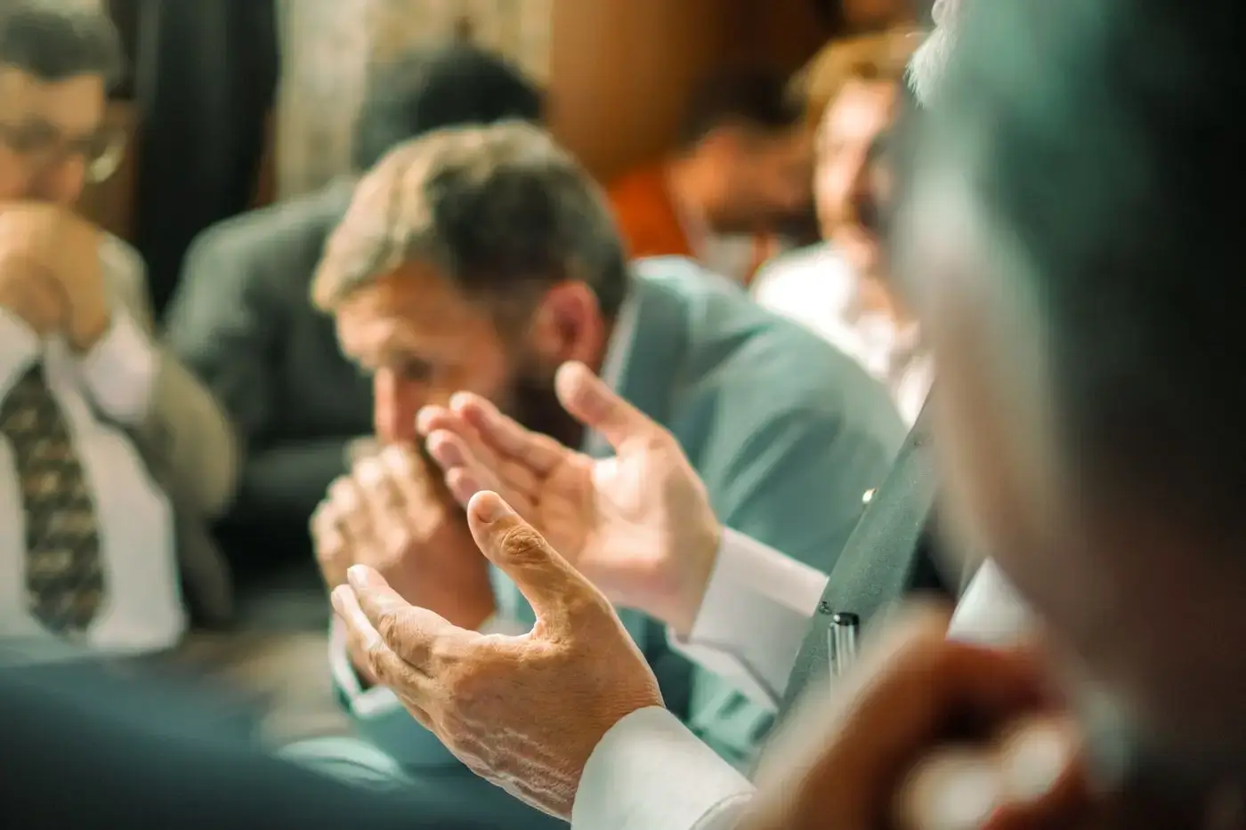 A man with hands folded in prayer during a church service